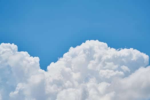 Vibrant image of fluffy white clouds against a clear blue sky, perfect for nature and weather themes.